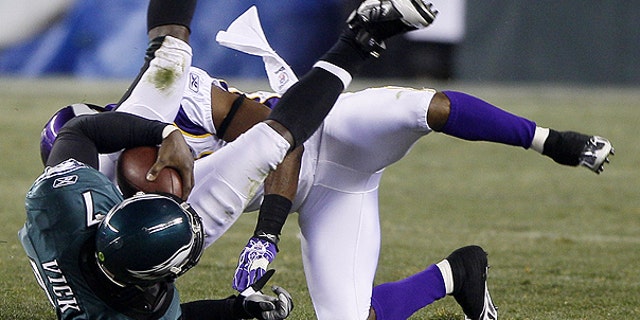 Dec. 28: Philadelphia Eagles quarterback Michael Vick, left, tumbles after a tackle by Minnesota Vikings cornerback Antoine Winfield in the first half of an NFL football game in Philadelphia.