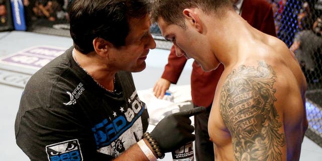 LAS VEGAS, NV - JULY 06: (L-R) Coach Ray Longo provides instruction to Chris Weidman between rounds of his UFC middleweight championship fight against Anderson Silva during the UFC 162 event inside the MGM Grand Garden Arena on July 6, 2013 in Las Vegas, Nevada. (Photo by Josh Hedges/Zuffa LLC/Zuffa LLC via Getty Images)