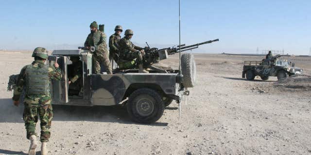 Dec. 23, 2015: Afghan National Army soldiers guard at a checkpoint on the way to the Sangin district of Helmand province, Afghanistan