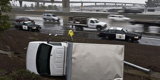 Dec. 29: A truck lands on its side after the driver lost control while driving too fast in the rain, and flipped over on the right shoulder of the northbound 57 in Anaheim, Calif.
