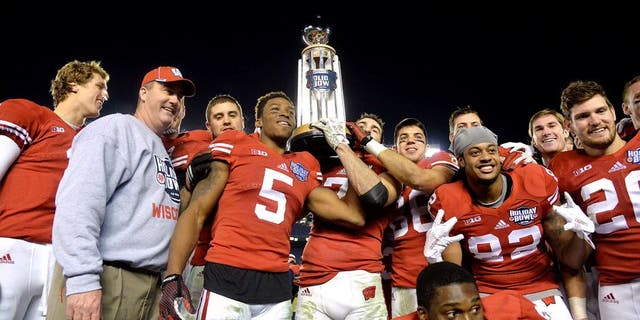 Dec 30, 2015; San Diego, CA, USA;Wisconsin Badgers players and head coach Paul Chryst hoist the championship trophy after the 2015 Holiday Bowl against the Southern California Trojans at Qualcomm Stadium. Wisconsin defeated USC 23-21. Mandatory Credit: Kirby Lee-USA TODAY Sports