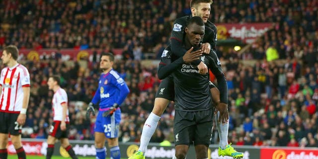 SUNDERLAND, ENGLAND - DECEMBER 30: Christian Benteke of Liverpool celebrates with team-mate Adam Lallana of Liverpool after scoring the opening goal as Sunderland players show their dejection during the Barclays Premier League match between Sunderland and Liverpool at Stadium of Light on December 30, 2015 in Sunderland, England. (Photo by Ian MacNicol/Getty Images)