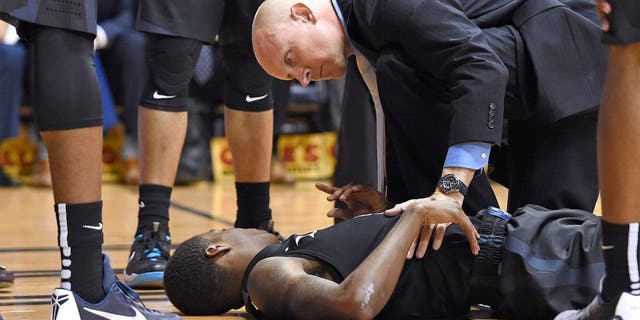 Dec 31, 2015; Villanova, PA, USA; Xavier Musketeers guard Edmond Sumner (4) is checked on by head coach Chris Mack (R) after being injured against the Villanova Wildcats during the first half at The Pavilion. Mandatory Credit: Eric Hartline-USA TODAY Sports