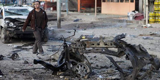 Jan. 24, 2012: A man inspects the scene of a car bomb attack in Sadr City eastern of Baghdad, Iraq.