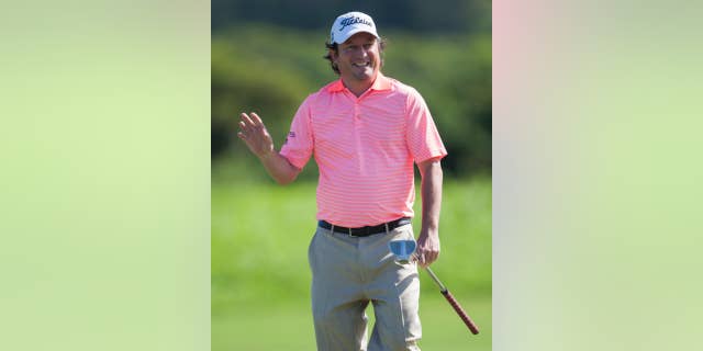 Tim Clark, of South Africa, waves to the gallery after making a birdie putt on the second green during the first round of the Tournament of Champions golf tournament, Friday, Jan. 9, 2015, in Kapalua, Hawaii. (AP Photo/Marco Garcia)