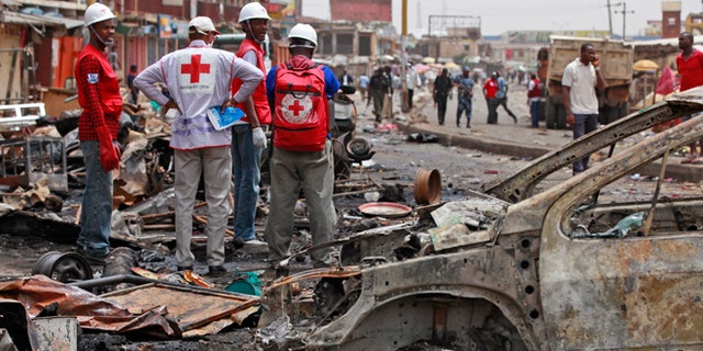 May 21, 2014: Red Cross personnel search for remains at the site of one of a car bomb in Jos, Nigeria.  Boko Haram militants are taking over villages in northeastern Nigeria, killing and terrorizing civilians and political leaders. (AP/Sunday Alamba/File)