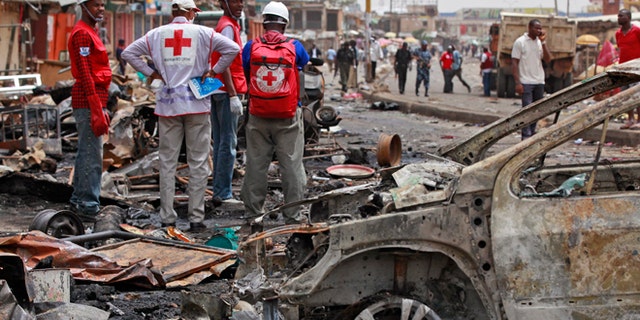 May 21, 2014: Red Cross personnel search for remains at the site of one of a car bomb in Jos, Nigeria. Boko Haram militants are taking over villages in northeastern Nigeria, killing and terrorizing civilians and political leaders. (AP/Sunday Alamba/File)