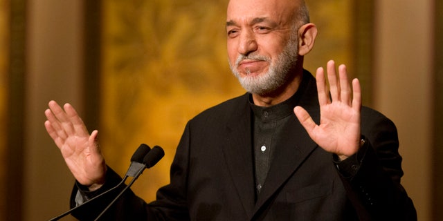 Afghanistan President Hamid Karzai gestures for applause to stop before he began his speech at Georgetown University in Washington, Friday, Jan. 11, 2013. (AP Photo/Jacquelyn Martin)