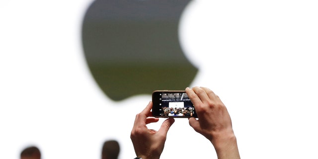 File photo: An audience member takes a photo of the Apple logo before the start of the company's annual developer conference in San Jose, California, U.S. June 5, 2017. REUTERS/Stephen Lam 