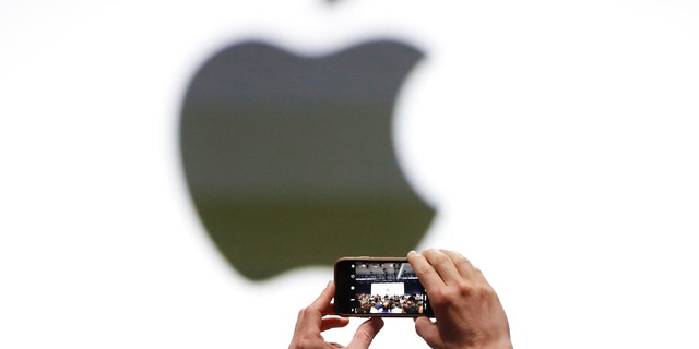 An audience member takes a photo of the Apple logo before the start of the company's annual developer conference in San Jose, California, U.S. June 5, 2017.