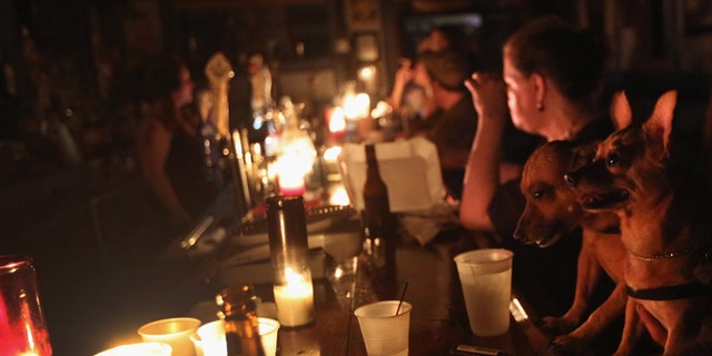 NEW ORLEANS, LA - AUGUST 31: Local residents drink by candle light at JJ's bar during the continued blackout on August 31, 2012 in the Bywater neighborhood of New Orleans, Louisiana. The area was still without electricity three days after Hurricane Isaac knocked out power to hundreds of thousands of people. (Photo by John Moore/Getty Images)