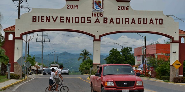 In this July 20, 2015 photo, a car drives past the entrance to the town of Badiraguato, Mexico.