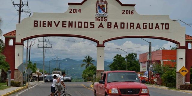In this July 20, 2015 photo, a car drives past the entrance to the town of Badiraguato, Mexico.