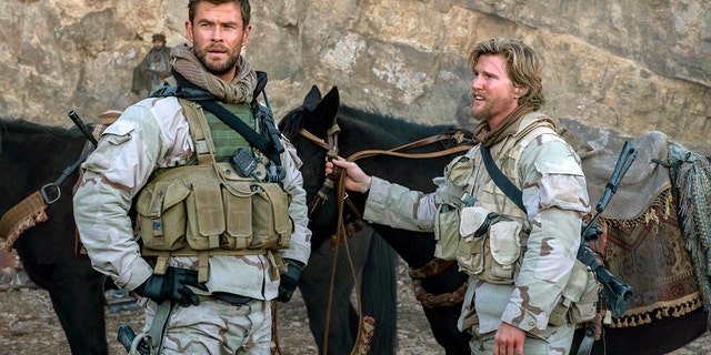 This image released by Warner Bros. Entertainment shows Chris Hemsworth, left, and Thad Luckinbill in a scene from "12 Strong." (David James/Warner Bros. Entertainment via AP)