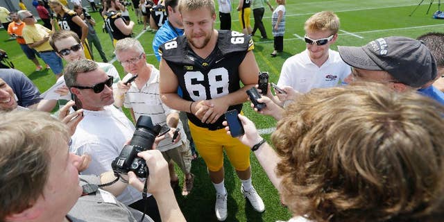 Iowa offensive linesman Brandon Scherff (68) speaks to the media during Iowa's annual college football media day, Monday, Aug. 4, 2014, in Iowa City, Iowa. (AP Photo/Charlie Neibergall)