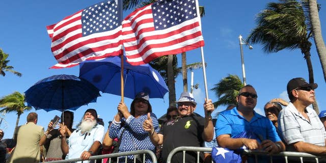 Pro-statehood supporters await the arrival of Puerto Rico's new governor at the seaside Capitol in San Juan, Puerto Rico, Monday, Jan. 2, 2017.  Ricardo Rossello was sworn in Monday as the U.S. territory prepares for what many believe will be new austerity measures and a renewed push for statehood to haul the island out of a deep economic crisis. (AP Photo/Danica Coto)