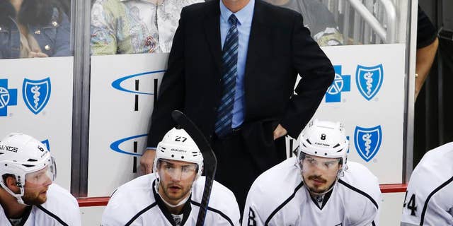 FILE - In this Thursday, Oct. 30, 2014, file photo, Los Angeles Kings assistant coach John Stevens stands behind his bench during the first period of an NHL hockey game against the Pittsburgh Penguins in Pittsburgh. A person with direct knowledge of the situation tells The Associated Press that the Los Angeles Kings will name Stevens their next head coach. Stevens replaces Darryl Sutter after serving as a Kings assistant and then associate coach for the past eight seasons, which included two Stanley Cups. (AP Photo/Gene J. Puskar, File)