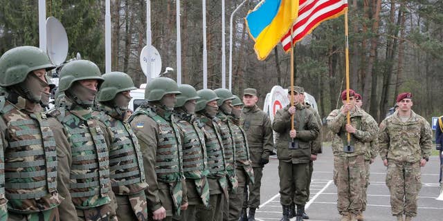 US and Ukrainian soldiers stand guard during opening ceremony of the 'Fiarles Guardian - 2015', Ukrainian-US Peacekeeping and Security command and staff training, in western Ukraine, in Lviv region, Monday, April 20, 2015. (AP Photo/Efrem Lukatsky)