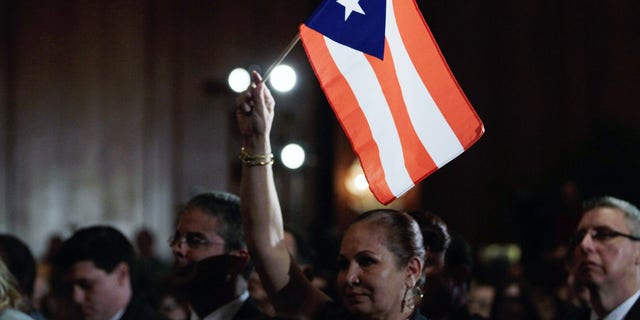MIAMI, FL - JANUARY 27:  Elizabeth Cuevas-Neunder holds a Puerto Rican flag as she listens to Republican presidential candidate and former Speaker of the House Newt Gingrich speak after he was endorsed by the National Hispanic Leadership Network at the Doral Golf Resort and Spa on January 27, 2012 in Miami, Florida. Gingrich is campaigning ahead of Florida's January 31, primary.  (Photo by Joe Raedle/Getty Images)