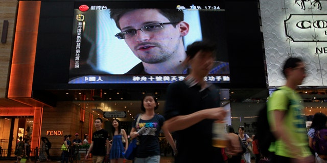 FILE - This June 23, 2013 file photo shows a TV screen shows a news report of Edward Snowden, a former CIA employee who leaked top-secret documents about sweeping U.S. surveillance programs, at a shopping mall in Hong Kong. The saga of Edward Snowden and the NSA makes one thing clear: The United States' central role in developing the Internet and hosting its most powerful players has made it the global leader in the surveillance game . Other countries, from dictatorships to democracies, are also avid snoopers, tapping into the high-capacity fiber optic cables to intercept Internet traffic, scooping their citizens' data off domestic servers, and even launching cyberattacks to win access to foreign networks. (AP Photo/Vincent Yu, File)