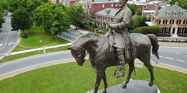 This Tuesday June 27, 2017, photo shows the statue of Confederate Gen. Robert E. Lee that stands in the middle of a traffic circle on Monument Avenue in Richmond, Va. As cities across the United States are removing Confederate statues and other symbols, dispensing with what some see as offensive artifacts of a shameful past marked by racism and slavery, Richmond is taking a go-slow approach. (AP Photo/Steve Helber)