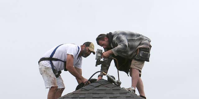 In this March 24, 2015 photo, roofers work on a new home in Panama City, Fla. The Federal Reserve releases its Beige Book report on Wednesday, April 15, 2015. (Andrew Wardlow/News Herald via AP)