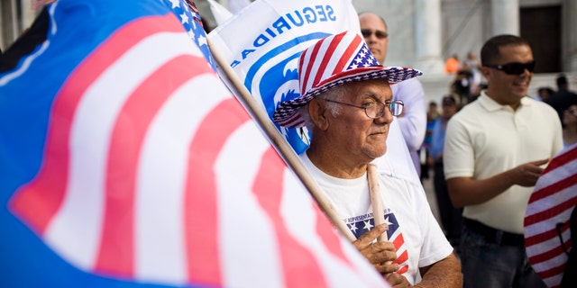 SAN JUAN, PUERTO RICO - MARCH 16:
Roberto Maldonado, 75, sells flags at a New Progressive Party rally where Republican presidential candidate, former Massachusetts Gov. Mitt Romney was campaigning on the North Side of the Capitol building March 16, 2012 in San Juan, Puerto Rico. Luis Fortuno, the island's governor and a Republican, has already expressed his support for the former governor for president. Romney's two-day campaign on the island is meant to win the 23 GOP delegates up for grabs on the U.S. territory. Romney's fiscal views are likely to resonate with the island's large private sector. (Photo by Christopher Gregory/Getty Images)