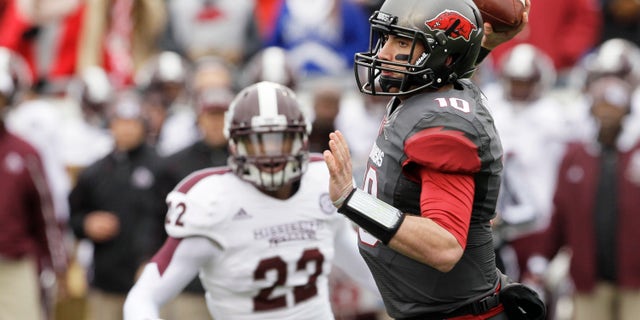 Arkansas quarterback Brandon Allen (10) passes in front of Mississippi State linebacker Matthew Wells (22) in the first half of an NCAA college football game in Little Rock, Ark., Saturday, Nov. 23, 2013. (AP Photo/Danny Johnston)