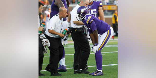 FILE - In this Sunday, Sept. 28, 2014, file photo, Minnesota Vikings quarterback Teddy Bridgewater talks to a trainer after getting injured in the second half of an NFL football game against the Atlanta Falcons in Minneapolis. Bridgewater's first start for the Vikings couldn't have been better, except of course for the sprained left ankle in the fourth quarter that forced him out of the 41-28 victory over Atlanta.(AP Photo/Ann Heisenfelt, File)