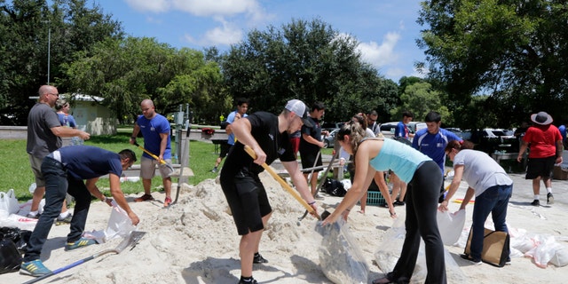 City of Miami volunteers help residents fill free sandbags Thursday, Sept. 7, 2017, in Miami, as residents prepare for Hurricane Irma. A hurricane watch is now in effect for the Florida Keys and parts of South Florida. (AP Photo/Alan Diaz)