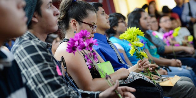 LOS ANGELES, CA - AUGUST 15: A group of immigrants, known as DREAMers, hold flowers as they listen to a news conference to kick off a new program called Deferred Action for Childhood Arrivals at the Coalition for Humane Immigrant Rights of Los Angeles on August 15, 2012 in Los Angeles, California. Under a new program established by the Obama administration undocumented youth who qualify for the program, called Deferred Action for Childhood Arrivals, can file applications from the U.S. Citizenship and Immigration Services website to avoid deportation and obtain the right to work (Photo by Kevork Djansezian/Getty Images)