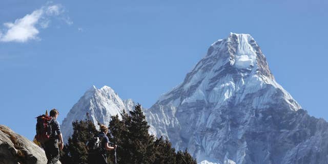 FILE - In this Feb. 19, 2016, file photo, trekkers make their way to Dingboche, a popular Mount Everest base camp, in Pangboche, Nepal. Officials say three foreign climbers; two British Kenton Cool, Robert Richard Lucas, and Mexican David Liano Gonzalez along with three Nepalese guides have scaled Mount Everest, the first foreigners to reach the summit in two years. (AP Photo/Tashi Sherpa, File)