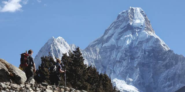 FILE - In this Feb. 19, 2016, file photo, trekkers make their way to Dingboche, a popular Mount Everest base camp, in Pangboche, Nepal. Officials say three foreign climbers; two British Kenton Cool, Robert Richard Lucas, and Mexican David Liano Gonzalez along with three Nepalese guides have scaled Mount Everest, the first foreigners to reach the summit in two years. (AP Photo/Tashi Sherpa, File)