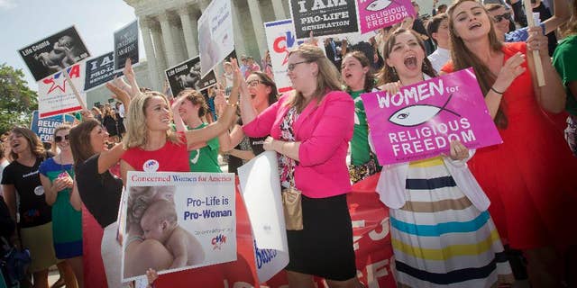 FILE - In this June 30, 2014 file photo, demonstrators react to hearing the Supreme Court's decision on the Hobby Lobby birth control case outside the Supreme Court in Washington. The Supreme Court rid itself Monday, May 16, 2016, of a knotty dispute between faith-based groups and the Obama administration over birth control. The court asked lower courts to take another look at the issue in a search for a compromise. (AP Photo/Pablo Martinez Monsivais, File)