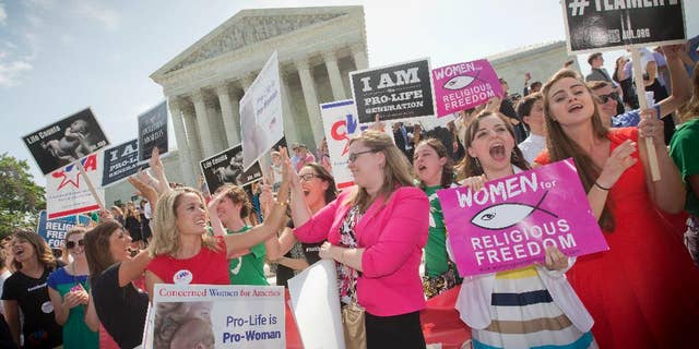 FILE - In this June 30, 2014 file photo, demonstrators react to hearing the Supreme Court's decision on the Hobby Lobby birth control case outside the Supreme Court in Washington. The Supreme Court rid itself Monday, May 16, 2016, of a knotty dispute between faith-based groups and the Obama administration over birth control. The court asked lower courts to take another look at the issue in a search for a compromise. (AP Photo/Pablo Martinez Monsivais, File)