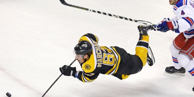 Boston Bruins left wing Brad Marchand (63) is tripped as he shoots on-goal after getting past New York Rangers defenseman Michael Del Zotto (4) during the second period in Game 1 of an NHL hockey playoffs Eastern Conference semifinal game in Boston, Thursday, May 16, 2013. (AP Photo/Charles Krupa)