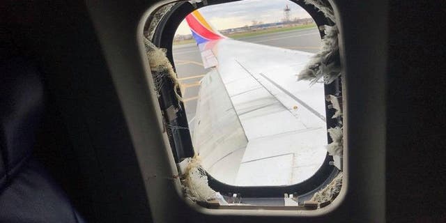 Shrapnel from the exploded engine shattered a window on the plane and partially sucked out a passenger.