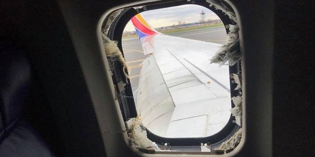 Shrapnel from the exploded engine shattered a window on the plane and partially sucked out a passenger.
