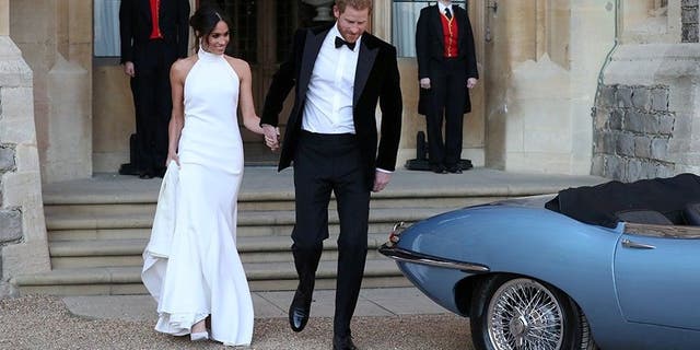 The newly married duke and duchess of Sussex, Meghan Markle and Prince Harry, prepare to leave Windsor Castle in a convertible car after their wedding in Windsor, England, to attend an evening reception at Frogmore House, hosted by the Prince of Wales, Saturday, May 19, 2018.