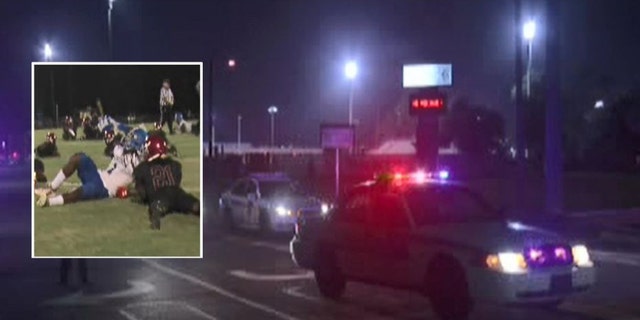Players are seen ducking for cover, inset, at Raines High School in Jacksonville, Fla., on Friday night. Police responded after gunfire at the game.