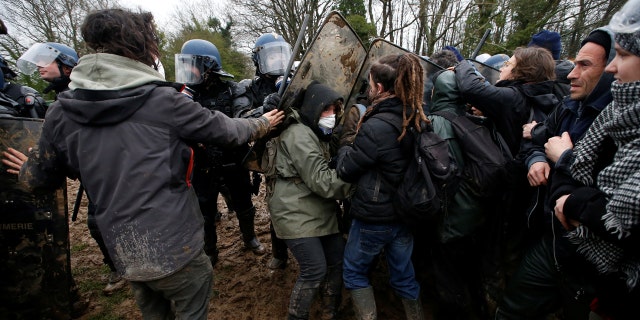 Protesters try to block French gendarmes during an evacuation operation.