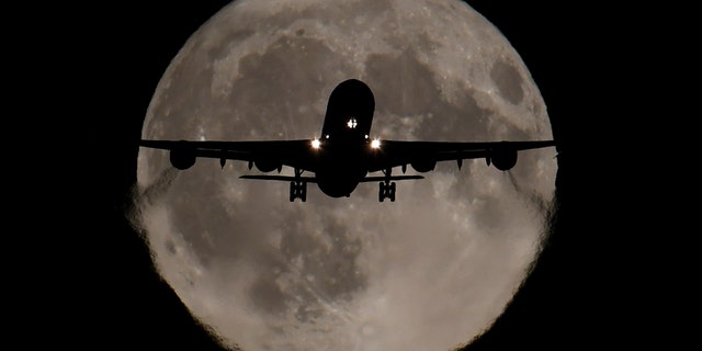 A passenger plane, with a full Harvest moon seen behind, makes its final landing approach towards Heathrow Airport in London, Britain, October 5, 2017 - file photo. REUTERS/Toby Melville
