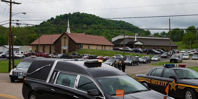 FILE – In this May 3, 2016, file photo, hearses for six of the eight members of the Rhoden family found shot April 22, 2016, at four properties near Piketon, Ohio, depart during funeral services from Dry Run Church of Christ in West Portsmouth, Ohio. The Ohio Supreme Court on Wednesday, April 19, 2017, ordered the Pike County coroner to submit unredacted autopsy reports from the unsolved slayings for justices to review outside of public view, as the court considers media lawsuits seeking access to those full reports. (AP Photo/John Minchillo, File)