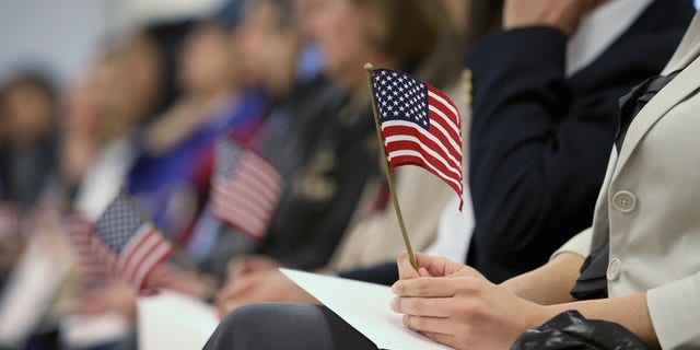 NEWARK, NJ - JANUARY 28: Immigrants hold flags while waiting for a naturalization ceremony to become U.S. citizens at the district office of U.S. Citizenship and Immigration Services (USCIS) on January 28, 2013 in Newark, New Jersey. Some 38,000 immigrants became U.S. citizens at the Newark office alone in 2012. (Photo by John Moore/Getty Images)