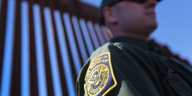 NOGALES, AZ - FEBRUARY 26: A U.S. Border Patrol agent stands at the U.S.-Mexico border fence on February 26, 2013 in Nogales, Arizona. Various federal agencies are tasked with securing the border from drug smugglers and illegal immigration in the Tucson sector of Arizona. (Photo by John Moore/Getty Images)