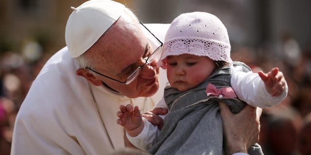 VATICAN CITY, VATICAN - MARCH 24: Pope Francis kisses 8-month-old Victoria Maria Marino from Sicily after delivering his blessing to the palms and to the faithful gathered in St. Peter's Square during Palm Sunday Mass on March 24, 2013 in Vatican City, Vatican. Pope Francis lead his first mass of Holy Week as pontiff by celebrating Palm Sunday in front of thousands of faithful and clergy. The pope's first holy week will also incorporate him washing the feet of prisoners in a youth detention centre in Rome next Thursday, 28th March. (Photo by Dan Kitwood/Getty Images)
