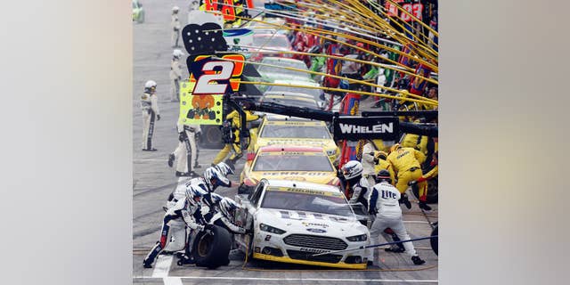 Brad Keselowski (2) leads cars in pit row during the NASCAR Sprint Cup series auto race at New Hampshire Motor Speedway, Sunday, Sept. 21, 2014, in Loudon, N.H. (AP Photo/Jim Cole)