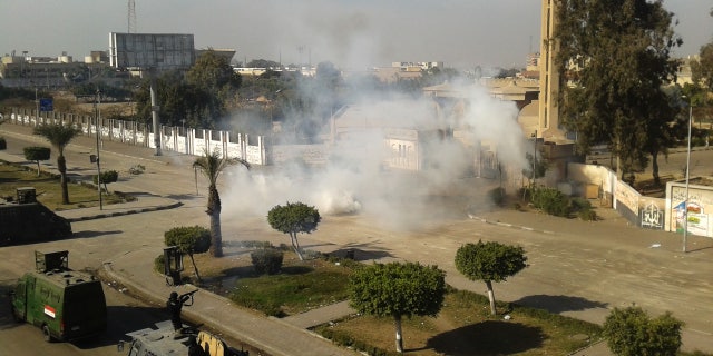 Egyptian security forces fire tear gas to disperse supporters of ousted President Mohammed Morsi as they protest at Al-Azhar University in Cairo, Egypt, Friday, Dec. 27, 2013. Armored vehicles closed main squares and city centers in Cairo and other major cities after Morsi's group, the Muslim Brotherhood, and its allies announced now protests in defiance of the interim government's latest move labeling the group as a terrorist organization. (AP Photo/Mohamed Hassan)