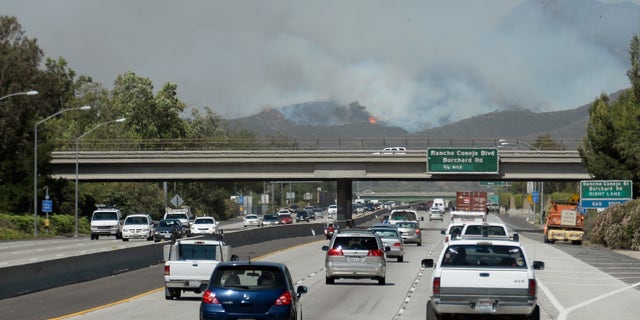 NEWBURY PARK, CA - MAY 02: Cars travel on the 101 Freeway as a wildfire burns in the hills nearby on May 2, 2013 in Newbury Park, California. Winds have made fighting the blaze, called the Springs Fire, more difficult and authorities have ordered some mandatory evacuations in the area. (Photo by Kevork Djansezian/Getty Images)