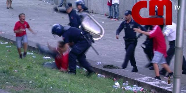 In this screen grab made from video provided by CMTV, a boy cries as his father is attacked by police with batons, outside of a stadium, in Lisbon, Portugal, late Monday, May 18, 2015. Portuguese prosecutors are investigating a policeman who beat a man in front of his young children and punched their grandfather outside a soccer stadium, sparking a national scandal. Police approached Jose Magalhaes, his two sons and his father Sunday outside Guimaraes stadium in northern Portugal, where Benfica had just won the Portuguese league title, according to film footage and witness reports. (CMTV via AP)